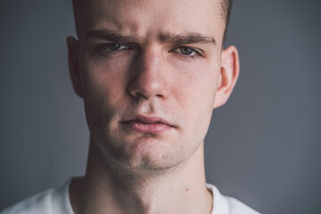Obraz premium portrait of a scowling offended young guy with a grimace on his face