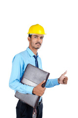 Young Indian male engineer wearing yellow color hard hat on white background.