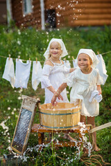 little sisters washing clothes outdoors