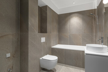 Naklejka na ściany i meble Modern minimalist bathroom beige interior design with marble tiles and beige furniture.