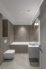 Modern minimalist bathroom beige interior design with marble tiles and beige furniture.