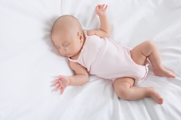 Cute little baby sleeping on bed, top view