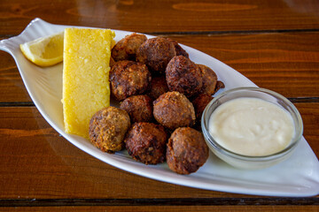 fish meat balls served with polenta and garlic sauce
