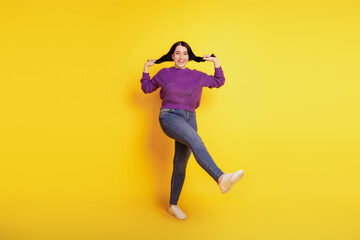 Fototapeta na wymiar Full size photo of attractive cheerful girl happy positive smile excited foolin hold tails jump isolated over yellow color background