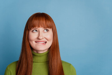 Portrait of funny minded inspired girl look copyspace on blue background