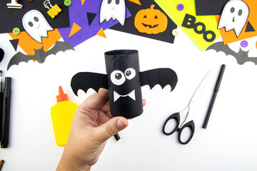 Craft with a child for Halloween from rolls of toilet paper and a black paper bat. Step-by-step...