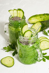 Green smoothie with cucumber in a glass jar. Fresh ripe vegetables, greens, and chia seeds