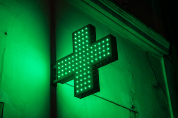 Green cross sign of a pharmacy at night