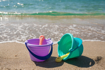 Shovels and buckets on coast sea background. Beach toys for family vacation.