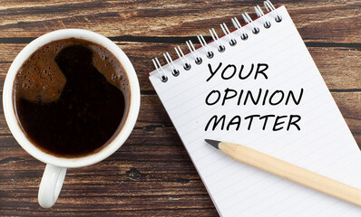 YOUR OPINION MATTER text on notebook with coffee on wooden background