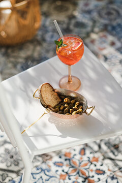 Glass of summer spritz cocktail and grilled Mediterranean olives