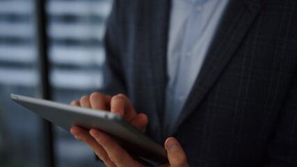 Businessman reading financial report on tablet. Male employee browsing internet 