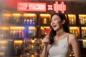 Nightlife concept a pretty girl with long hair wearing white and jeans holding a pink drink appreciating the musics alone in the bar