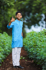 Cute indian little child in traditional wear and standing at agriculture field