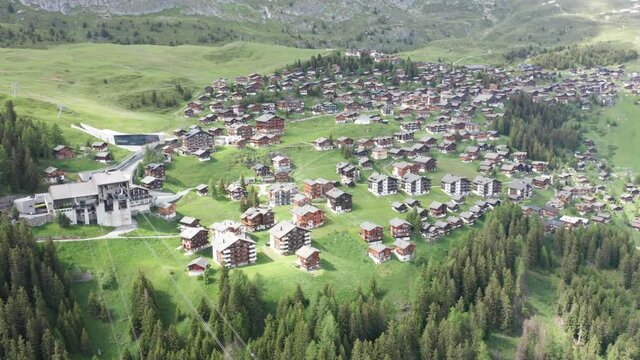 ski town in swiss alps from aerial view in 4k