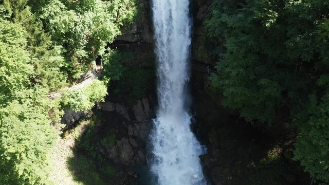 waterfall in swiss alps forest from aerial view in 4k