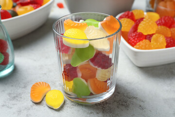 Delicious gummy candies on light grey table