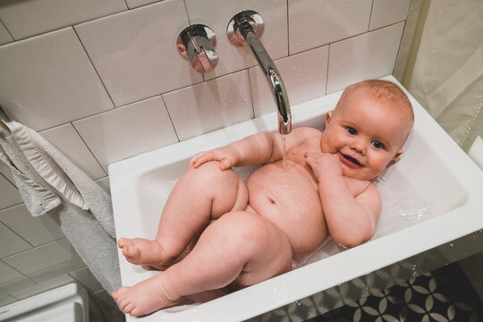 Baby lying in bathroom sink