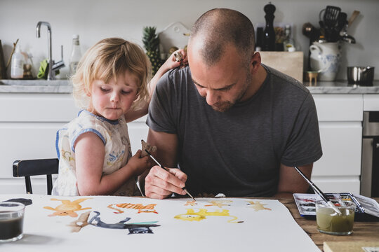 Father and daughter painting together