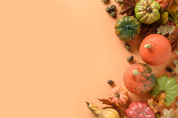 Festive frame of pumpkins, colorful leaves on orange background with space for text. Thanksgiving Day and Halloween template. View from above.