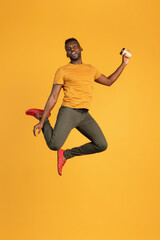 Fototapeta na wymiar Portrait of African young man in casual clothes isolated on yellow color studio background. Concept of human emotions, facial expression, youth, feelings, ad.