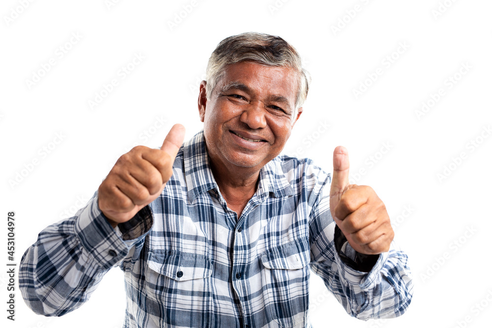 Poster portrait of an elderly man smiling and thumbs up looking at camera, isolated on white background.