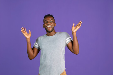 Fototapeta premium African-american young man's portrait on purple color studio background. Concept of human emotions, facial expression, youth, feelings, ad.