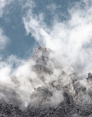 Beautiful snow-capped rocky mountains surrounded by clouds. Mobile phone screensaver. High quality photo