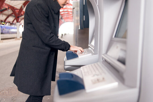 Man using ticket machine at train station