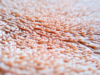 Macroshot texture of orange terry cloth with copy space. Selective focus surface of fuzzy towel. Things for home use.