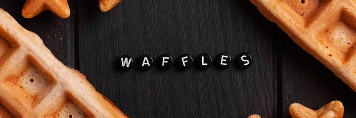 Fresh homemade Belgian waffles with blueberries on an old table with inscription banner.