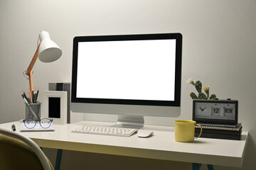 Mock up with blank screen of  computer, table lamp, pens, keyboard and mouse on the white desk.
