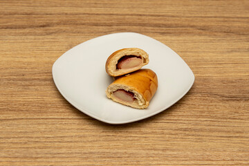 Venezuelan cachito stuffed with ham and fresh cheese on the white plate. Venezuelan breakfast