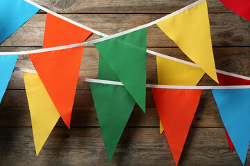 Colorful bunting party flags hanging on wooden wall. Festive decor