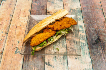 Sandwich of fried breaded chicken breast fillets with lettuce and mayonnaise on glass plate