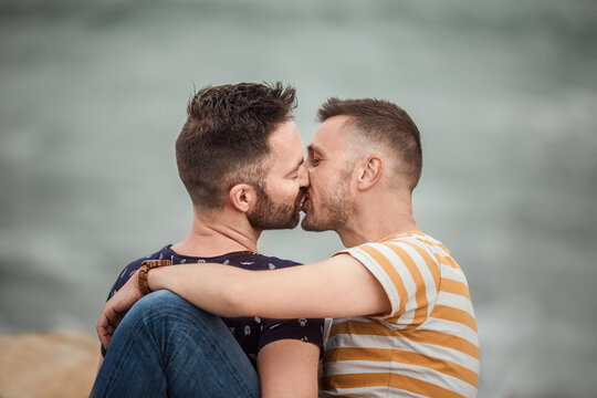 Couple of gays embracing and kissing in daytime