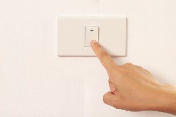 woman using index finger to turn off the light