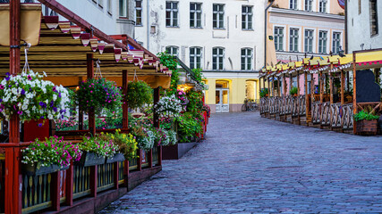 Cobbled street with wooden benches with flowers in Tallinn Estonia.
