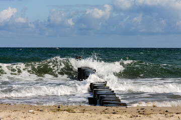 A wave floods a groyne on the Baltic Sea beach 