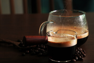 Strong hot coffee with beans on dark background