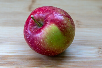 
Ripe red apple on the background of natural light wood