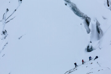 Climbers pass a glacier in the Italian mountains, the Dolomites Alps