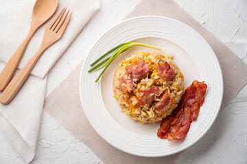 Fried Rice with Crispy Bacon.Stir fried jasmine rice with bacon carrot and egg in white plate.Top view
