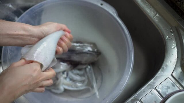 Hands taking squid bone off from body preparing seafood