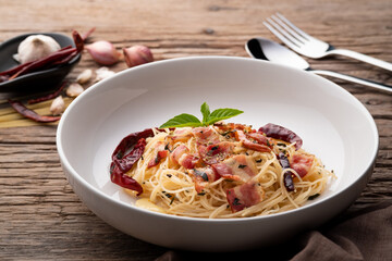 Stir-Fried Capellini pasta With Dried Chili And Crispy Bacon on white plate