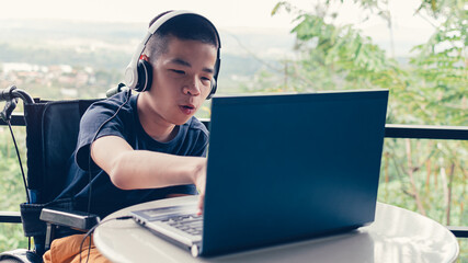 Confident of asian disabled teen boy on wheelchair using computer making video remote learning,...