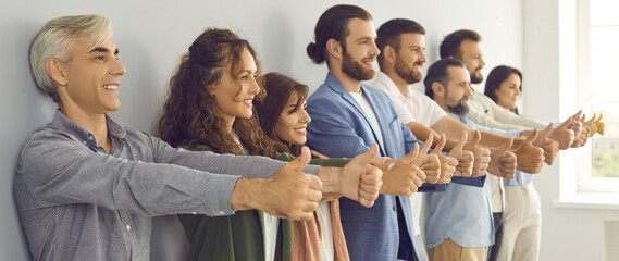 Team of smiling modern business people doing like gesture together. Group of ambitious confident...