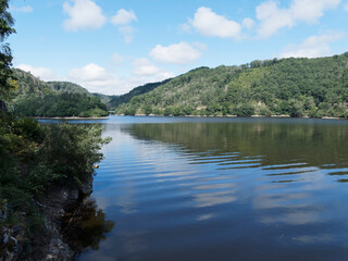 Fototapeta na wymiar Paysages des lacs d'Auvergne - Patrimoine et nature des Combrailles. Plan d'eau et barrage des Fades-Besserve sous un ciel bleu d'été