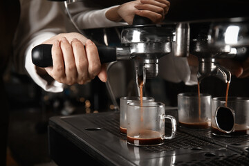 Barista making espresso using professional coffee machine, closeup