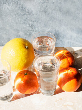 Studio shot of citrus fruits and glasses of water